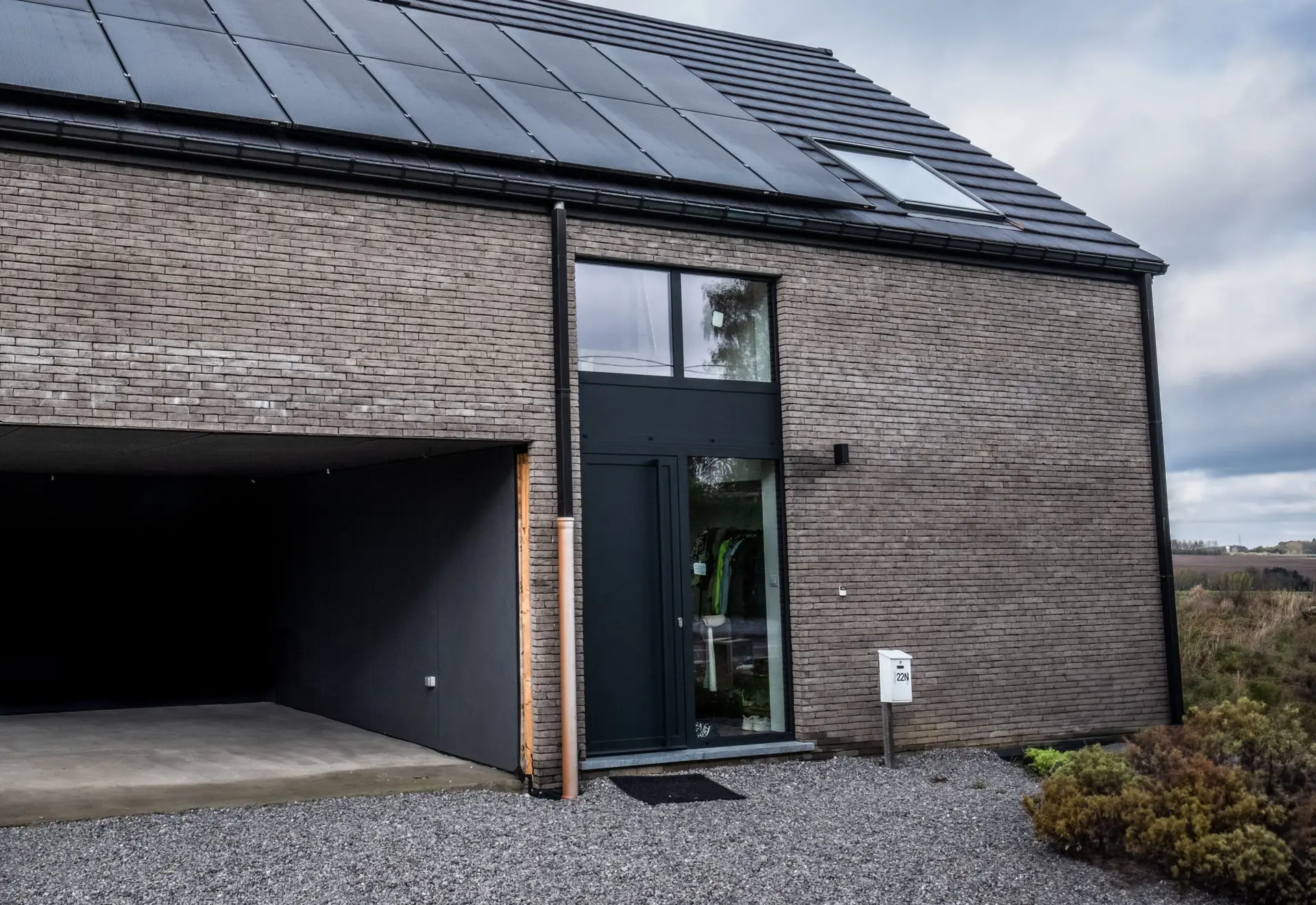 maison moderne avec grande porte securisée et baie vitrée sur deux étages