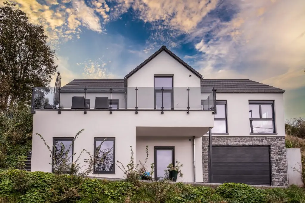 Maison en crépi blanc avec une grande porte de garage